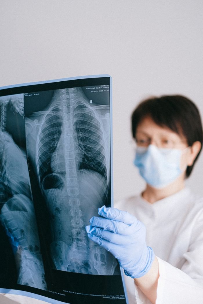 Mastering the First Impression: Your intriguing post title goes here A doctor wearing a face mask examines an x-ray with concentration, displaying a medical professional's focus.
