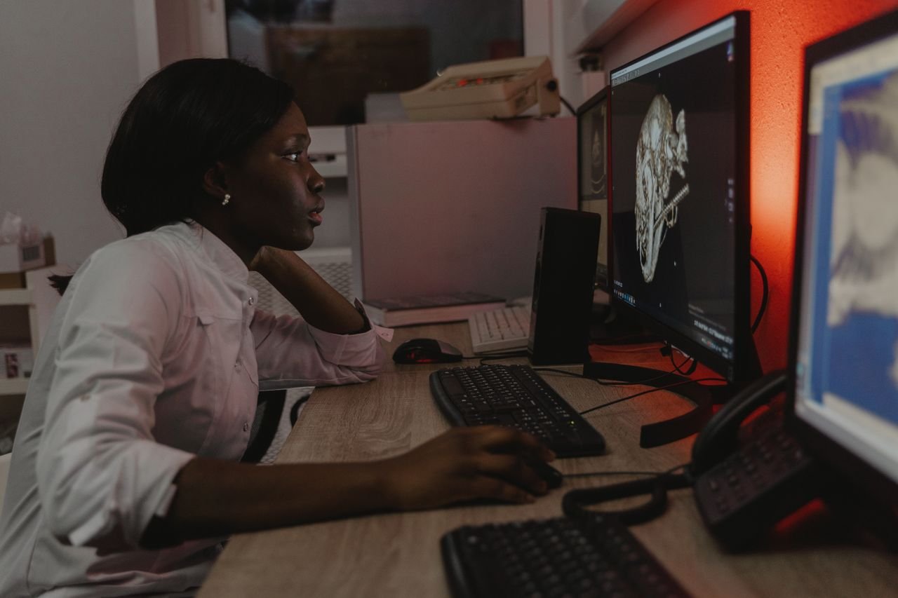 about-us-01 Veterinarian analyzing a 3D skull scan on dual monitors in an office setting.